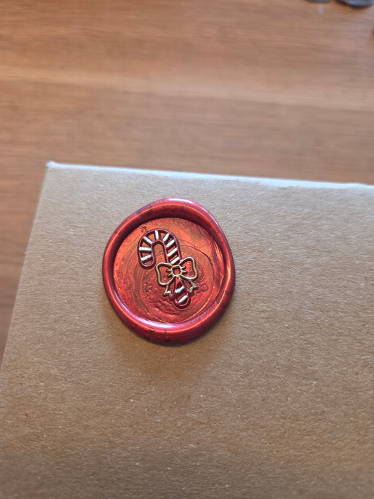 rode glanzende wax zegel met zuurstok motief met goud en witte details
