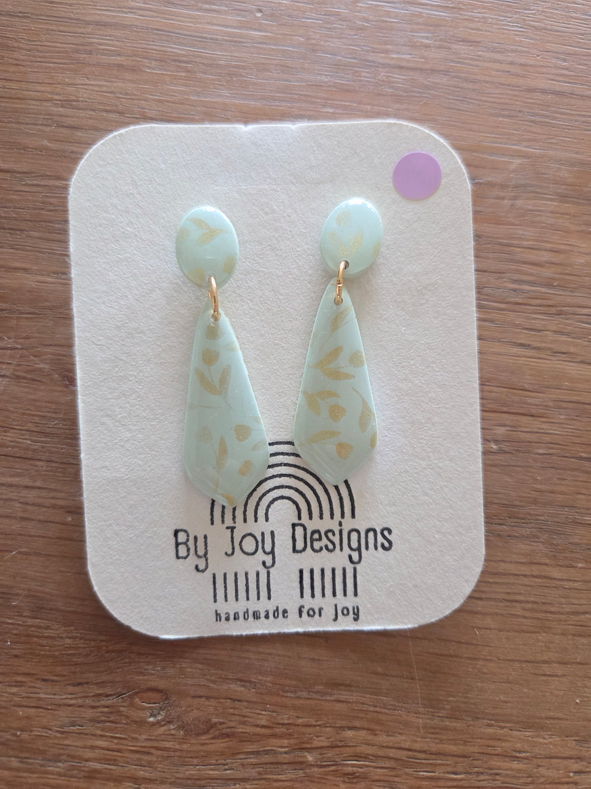 Lange mintgroene druppelhangers van polymeerklei met gouden bladprint en ovaal studje op een By Joy Designs kaartje