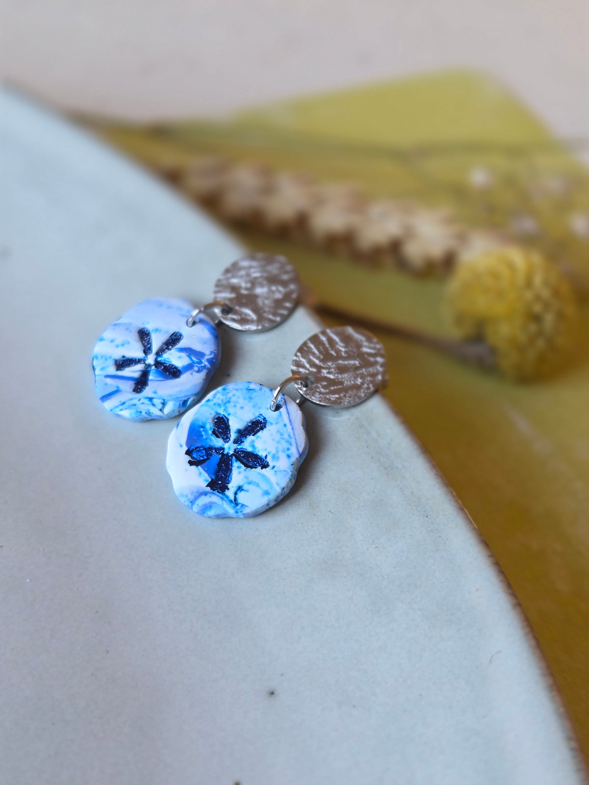 Ronde hangers in wit en Delfts blauw met donkerblauw stermotief aan getextureerde zilveren studs 