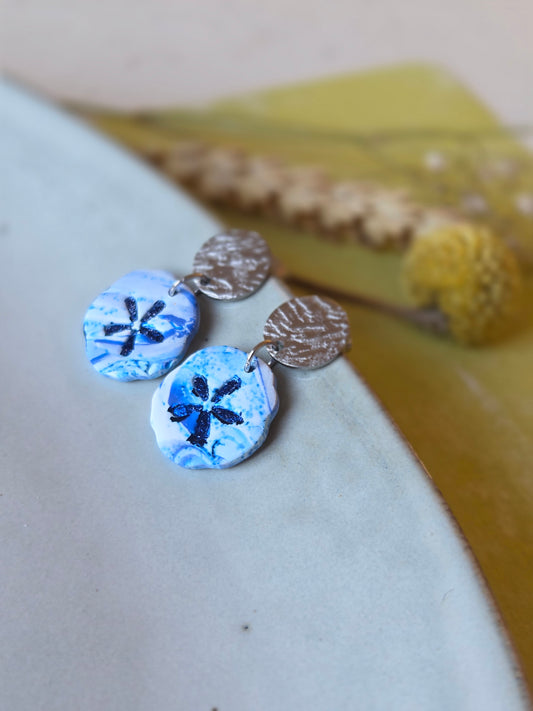 Ronde hangers in wit en Delfts blauw met donkerblauw stermotief aan getextureerde zilveren studs 